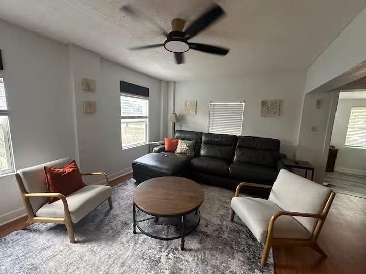 Living room seating area with natural light from front windows
