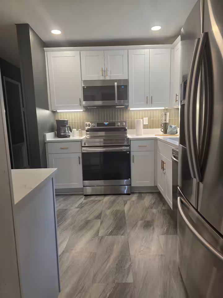 Renovated kitchen with white cabinetry and stainless appliances