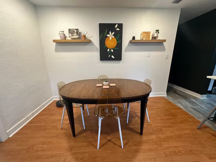Dining table for six beneath original citrus-blossom artwork