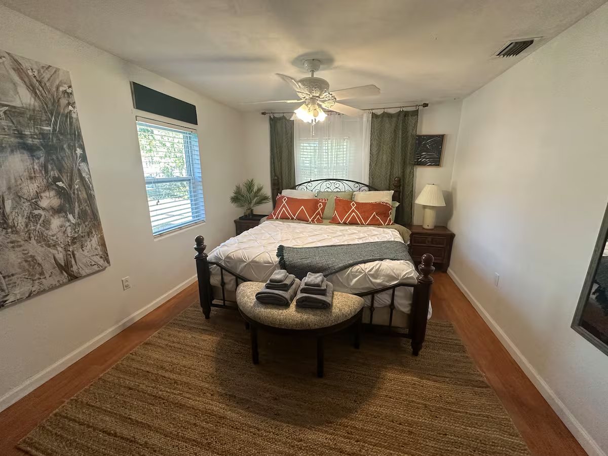 Primary bedroom with king bed and botanical artwork