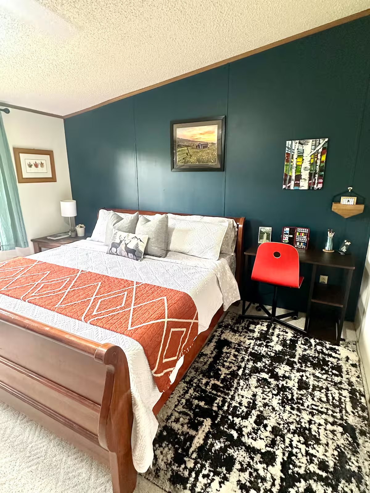 Primary bedroom with king bed and teal accent wall