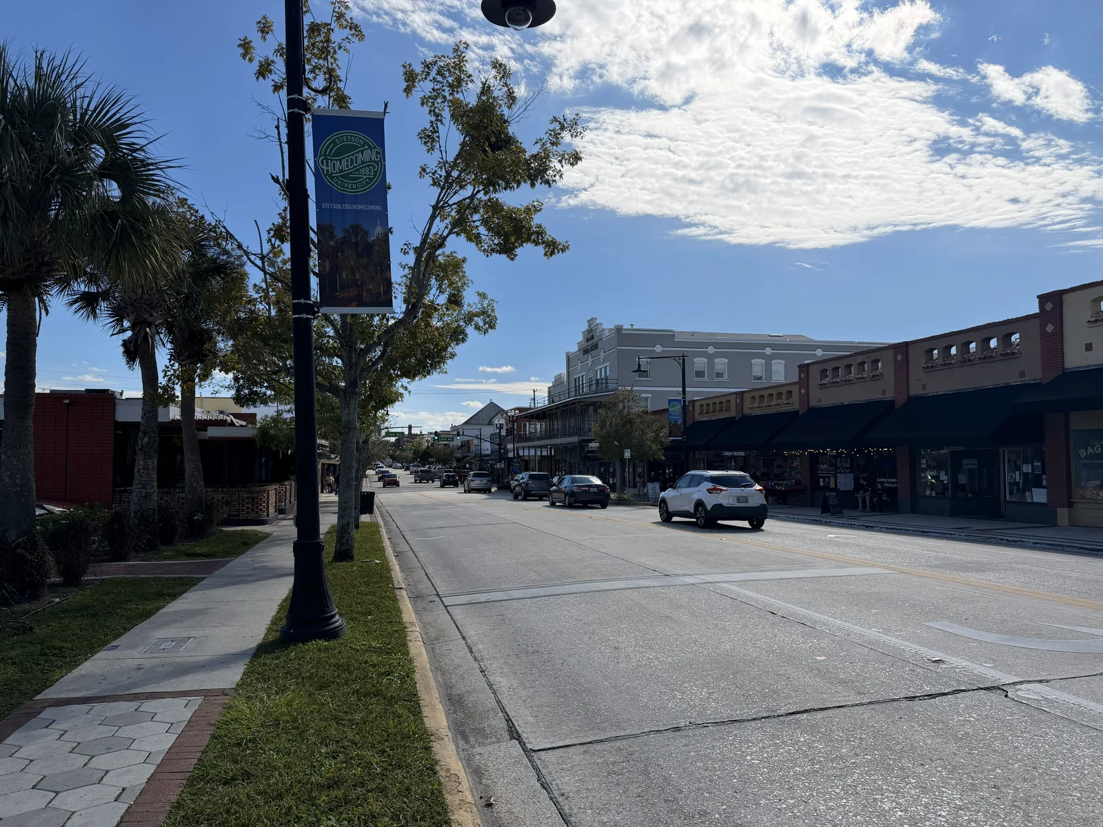 Historic Woodland Boulevard in downtown DeLand, Florida, lined with storefronts and palm trees