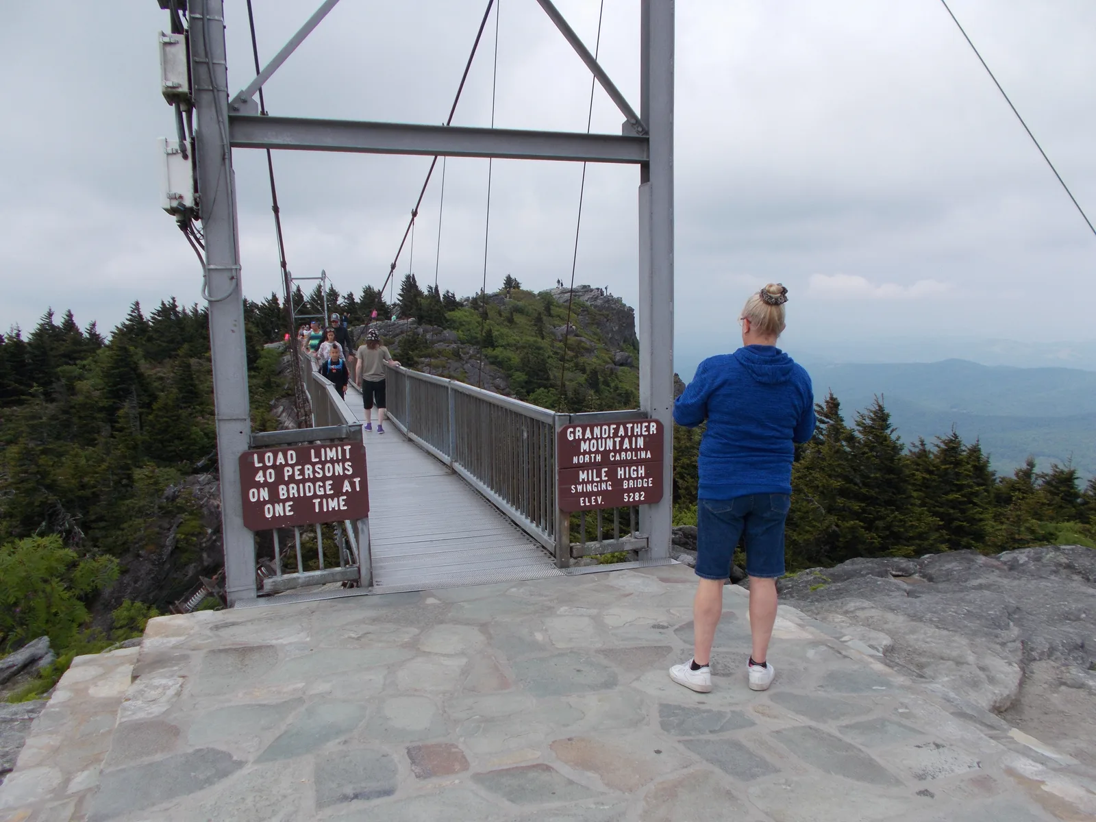 A visitor at the Mile High Swinging Bridge at Grandfather Mountain, North Carolina, overlooking the Blue Ridge Mountains