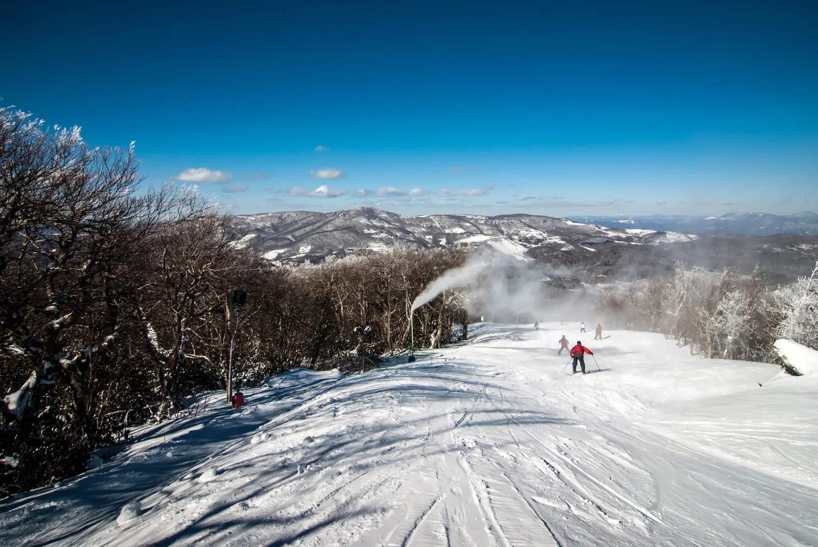 Skiers on a snow-covered slope at Sugar Mountain Resort, North Carolina, with mountain views